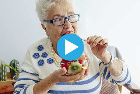 Woman eating fruit from a bowl