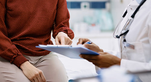 Patient pointing on clipboard held by a doctor