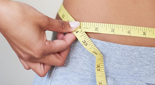 Woman measuring her waist